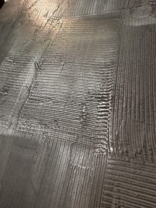 Eine detailreiche Metallstruktur verleiht der Wandgestaltung im Wohnzimmer einen modernen und edlen Look.