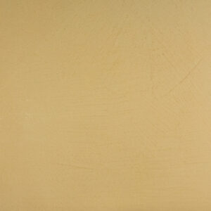 Eine glatte, beige Wand zeigt den eleganten Marmorputz von Einhornwerke als kreative Wandgestaltung im Wohnzimmer.