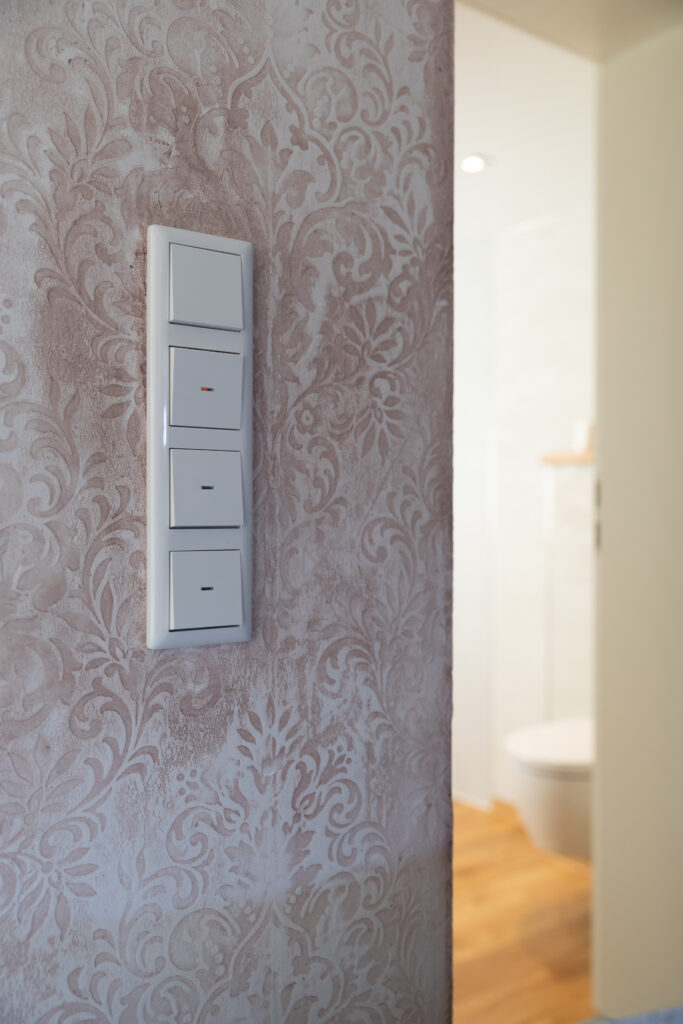 Eine kunstvoll gestaltete Wohnzimmerwand mit Oberflaeche-STUCCORINO Struktur zeigt elegante Marmorputzdetails.