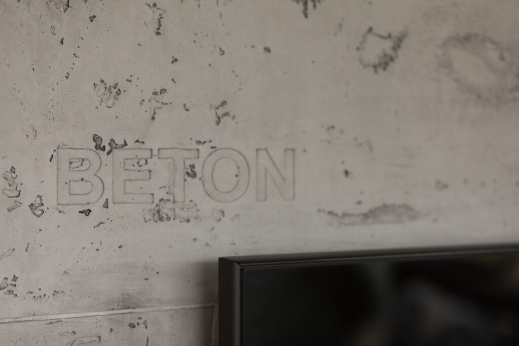 Die Betonwand im Wohnzimmer zeigt moderne Wandgestaltung mit Oberflaeche STUCCORINO Betonoptik.
